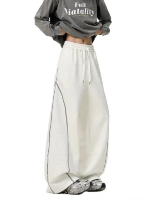 White Flower Gray oversized contrast stitch balloon sweatpants front low angle view with elastic drawstring waist and wide stacked legs