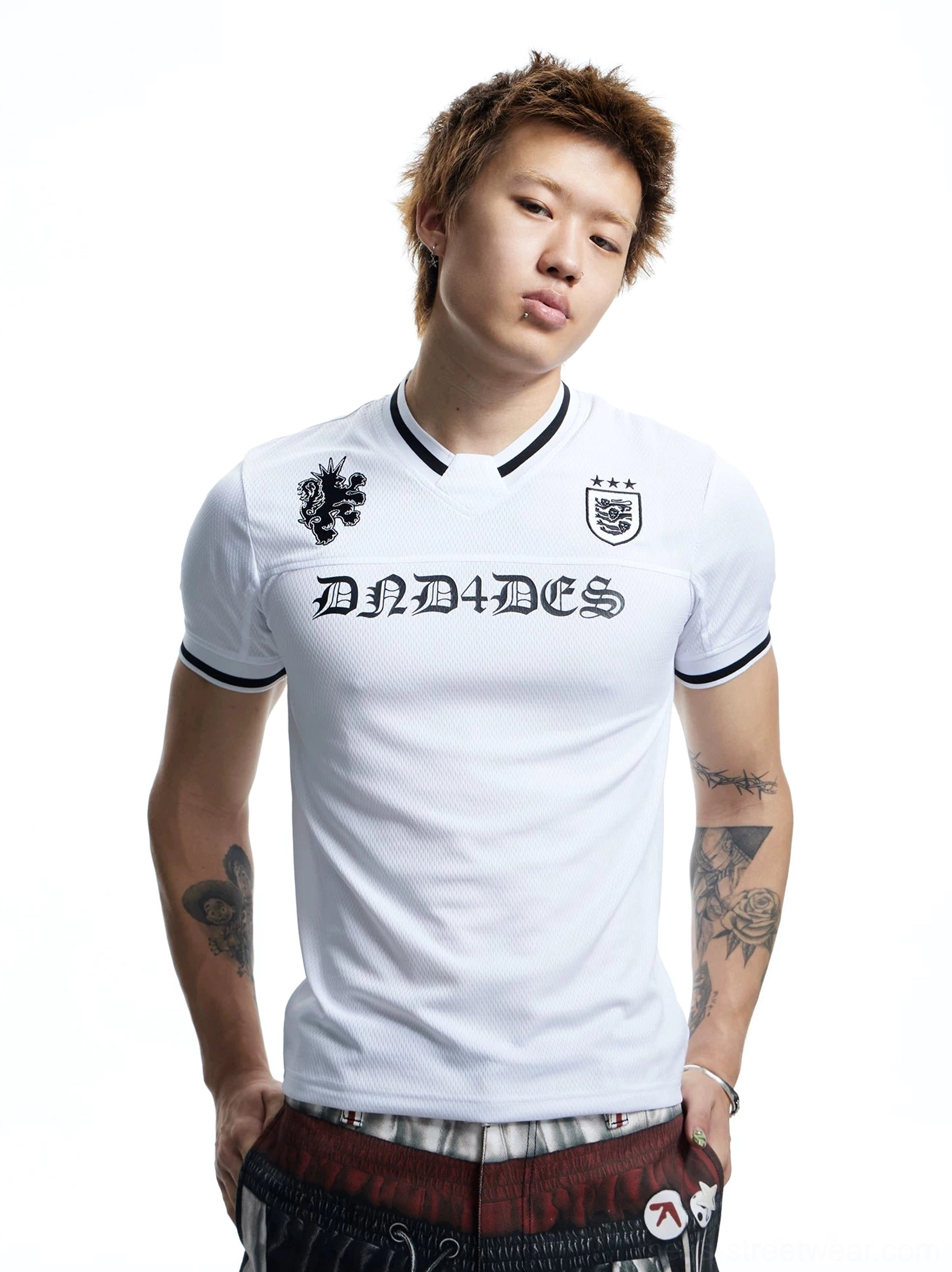 Front view of a white football jersey mesh T-shirt with black Gothic chest graphics, crest detail, V-neck trim, and short sleeve streetwear silhouette