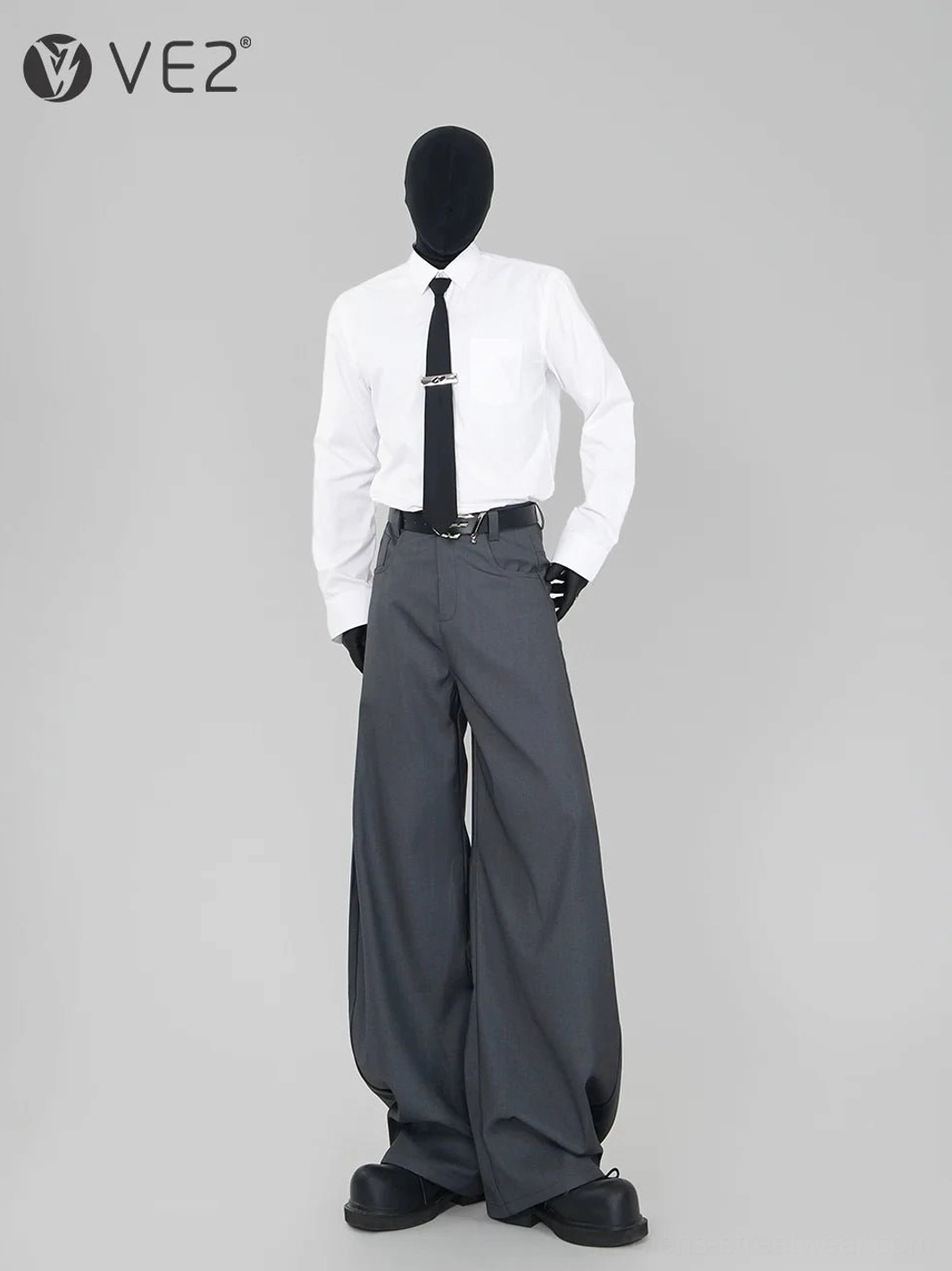White formal button-up dress shirt with necktie styled with wide-leg gray trousers and platform leather shoes