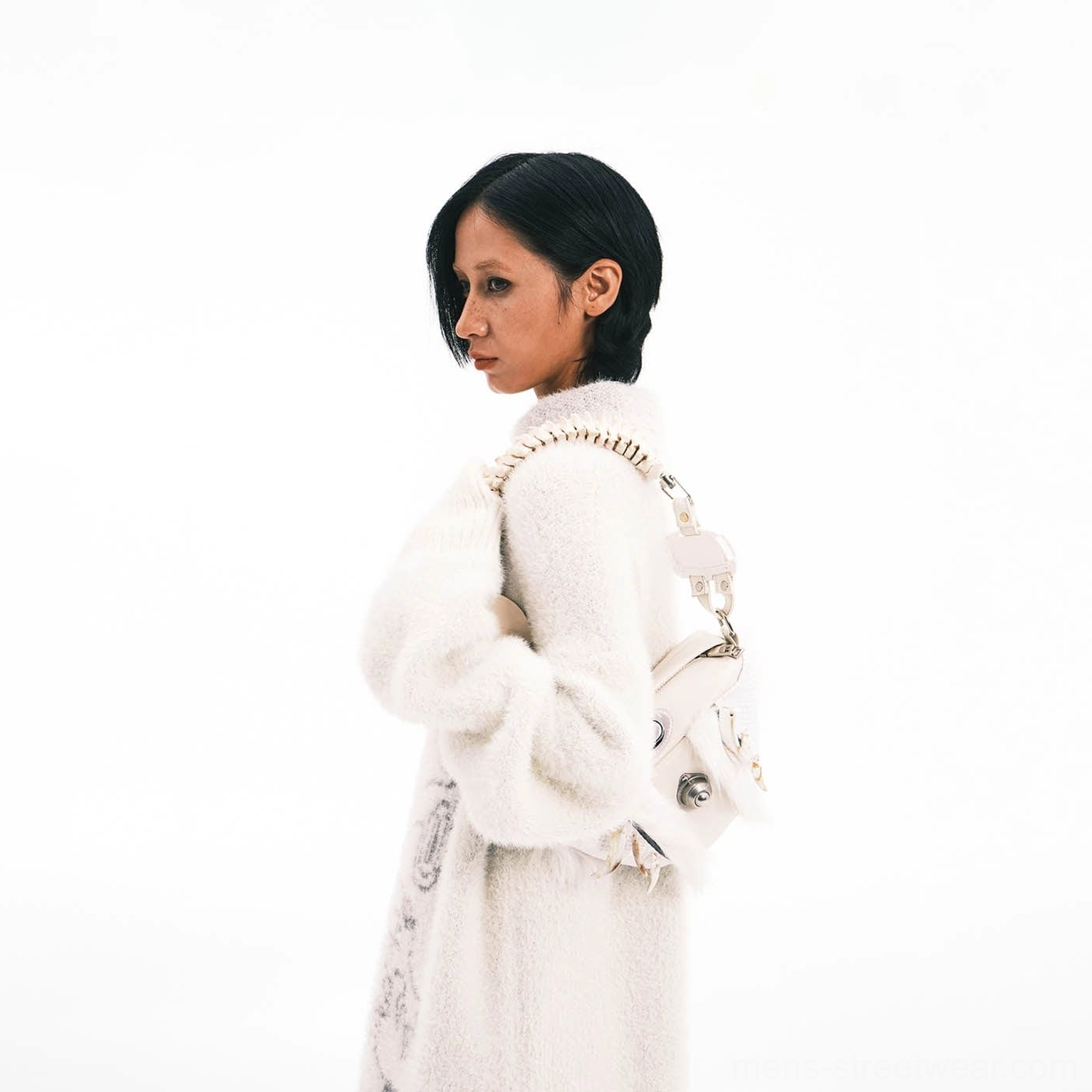 White fur shoulder bag with faux bone spine handle worn with tonal white fuzzy knit streetwear outfit