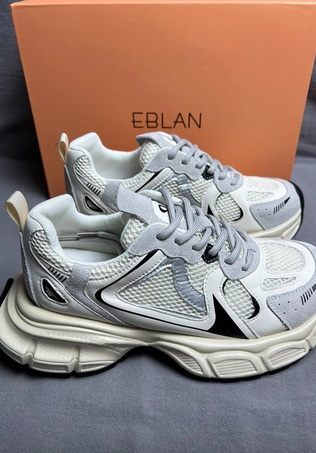 White and gray retro chunky runner sneakers with black contrast details and heel pull tab