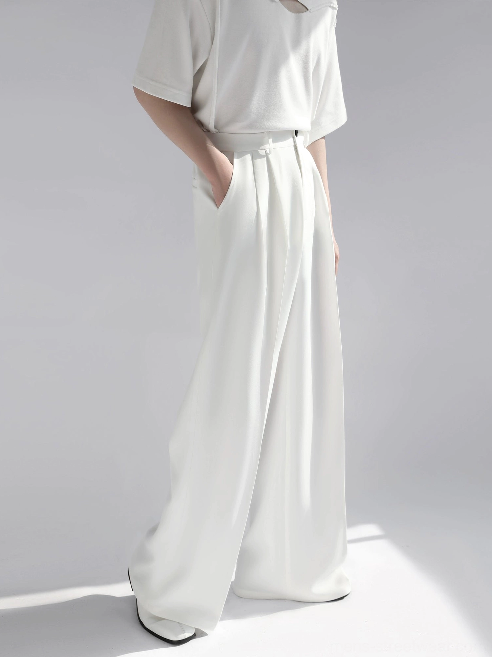 White high-waist wide leg tailored trousers side full body view showing side pocket and fluid drape