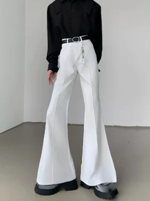 White high-waisted flared suit trousers with front crease, wide bell-bottom legs, black belt styling, and metal chain accent in a Seoul streetwear outfit