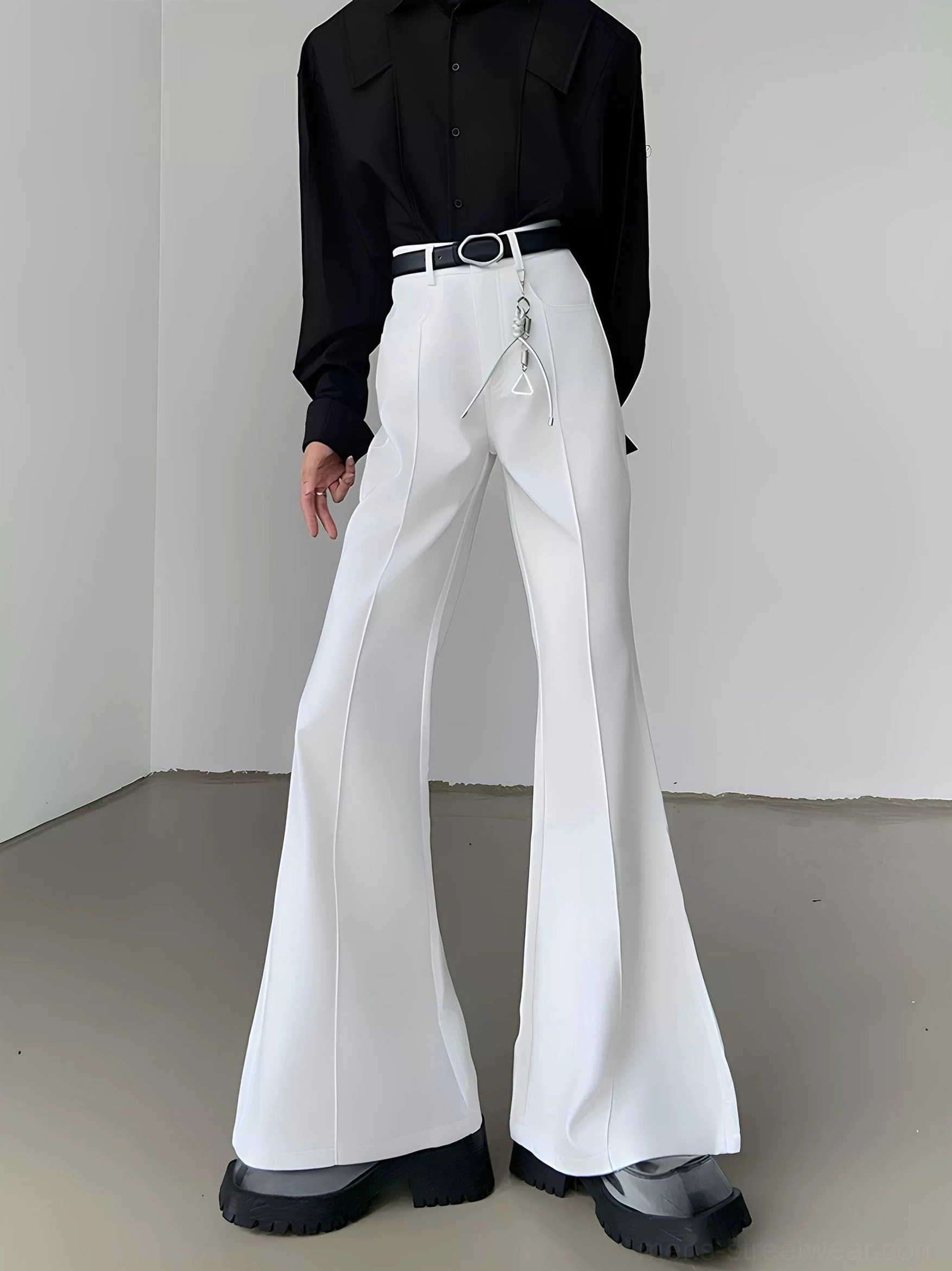 White high-waisted flared suit trousers with front crease, wide bell-bottom legs, black belt styling, and metal chain accent in a Seoul streetwear outfit