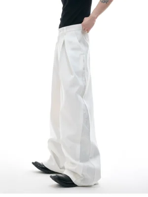 White high-waisted wide-leg trousers shown from the rear side with pleated front and embroidered decorative panel