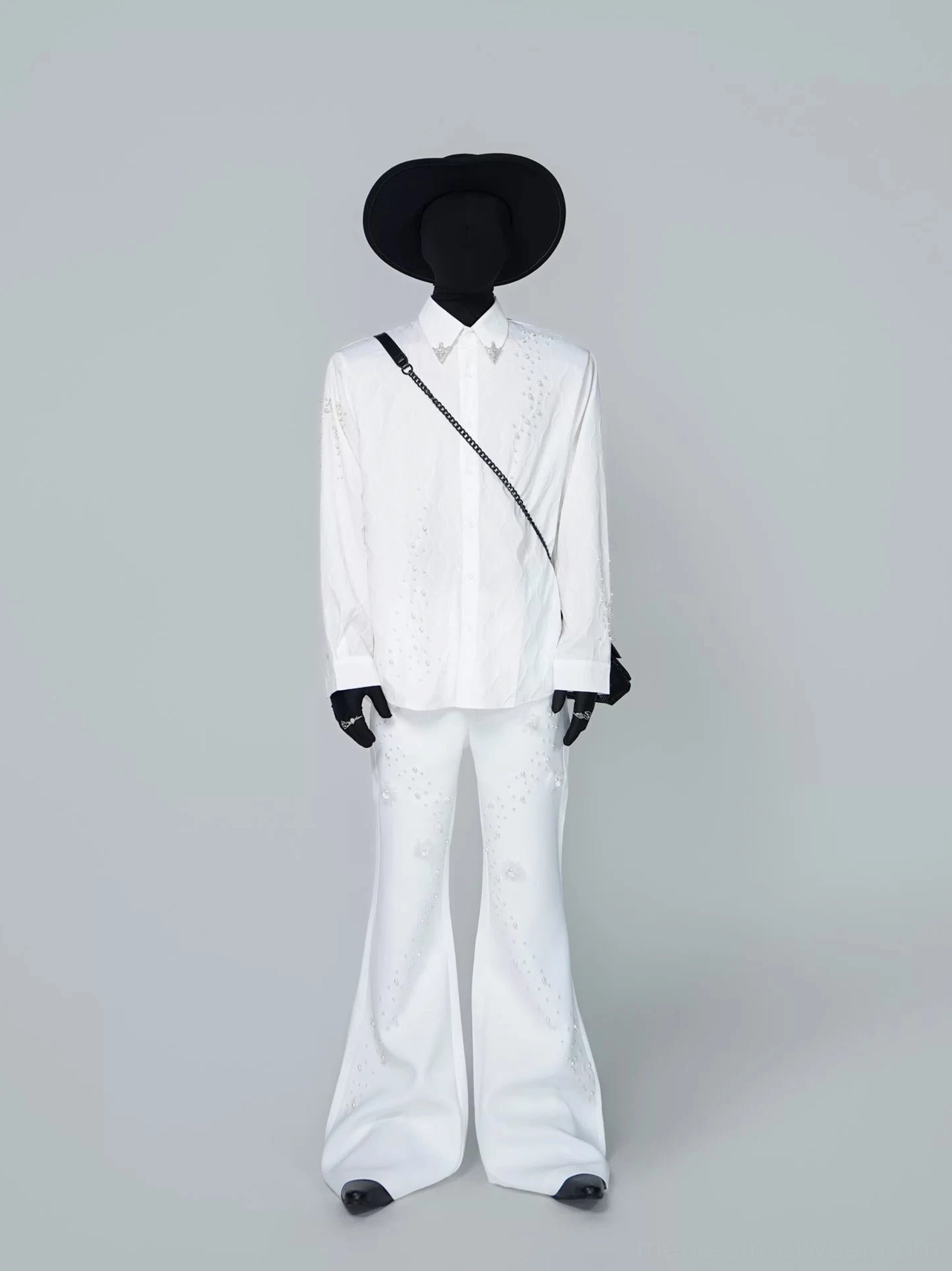Side-back view of white Korean streetwear embellished shirt styled with high-waisted flared trousers, black cowboy hat, and chain crossbody bag