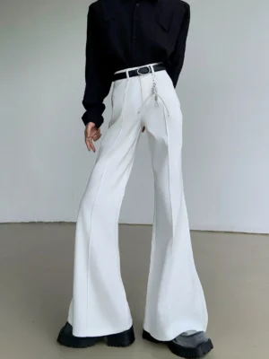 White Korean streetwear flare trousers shown from a three-quarter angle with tailored vertical seam, wide leg silhouette, black belt, and metal accessory