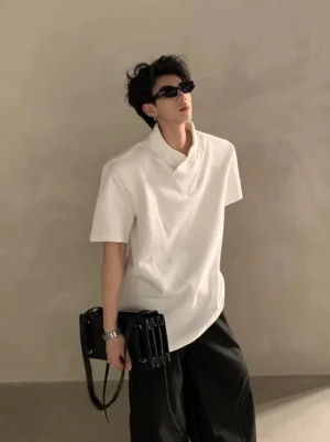 White layered high-collar short-sleeve streetwear shirt with asymmetric hem on male model wearing sunglasses and crossbody bag