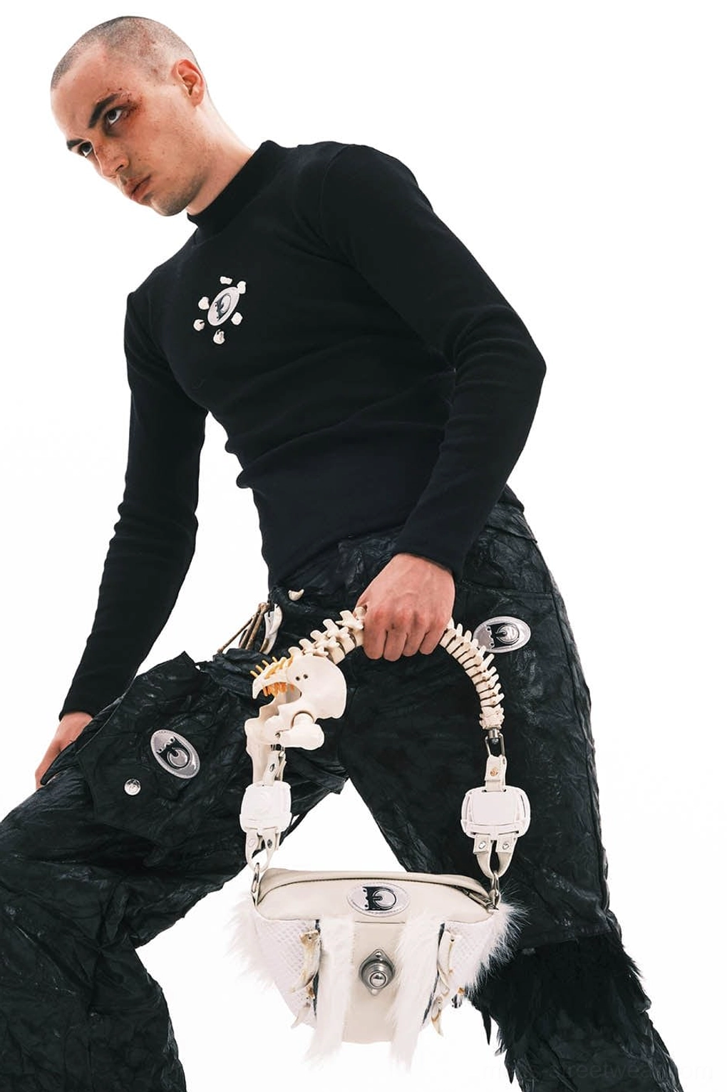 White leather fur bag with sculptural faux bone handle and silver hardware held by male streetwear model