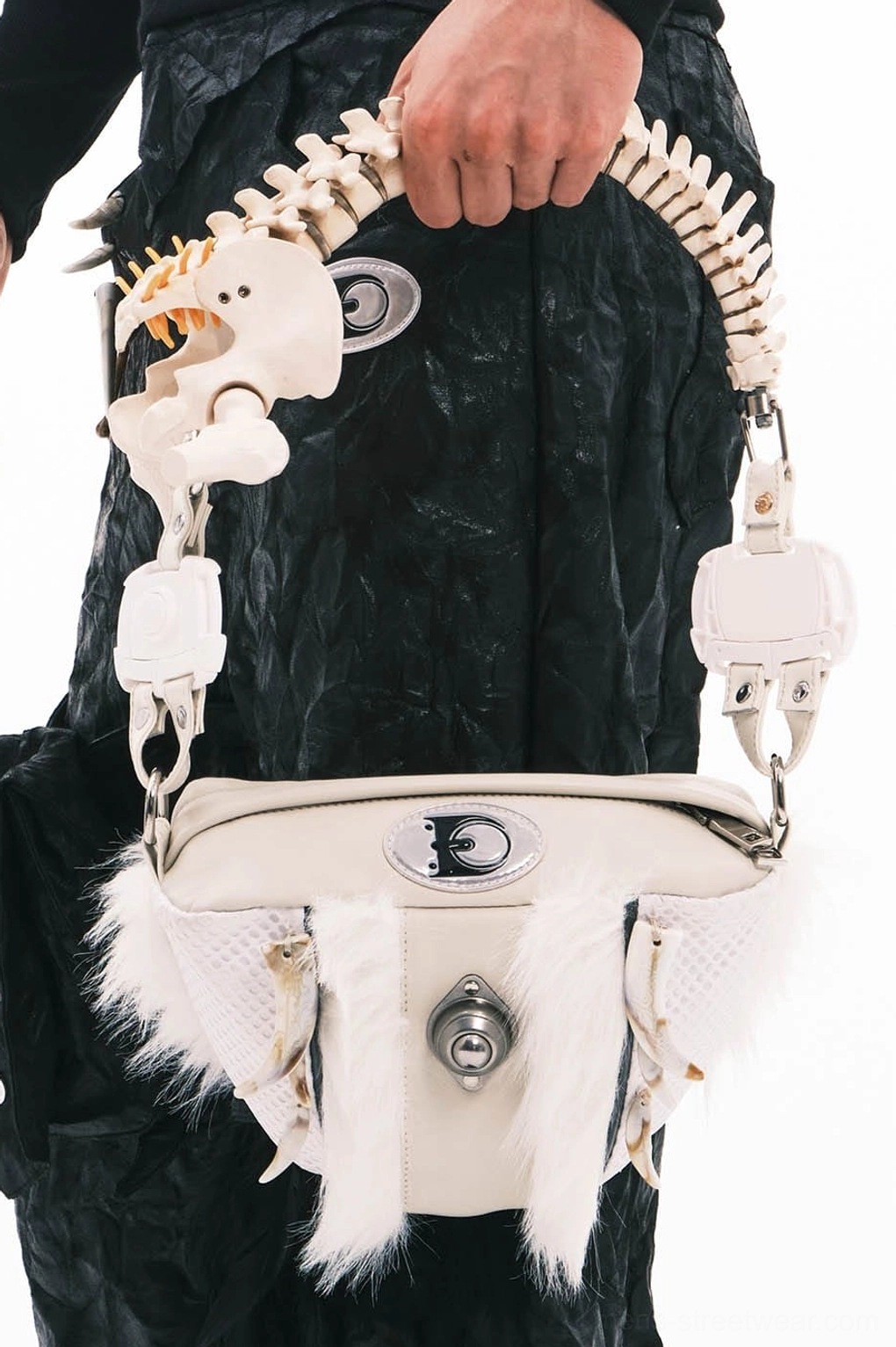 Close-up of white leather fur bag showing turn-lock closure silver hardware and resin faux bone spine handle
