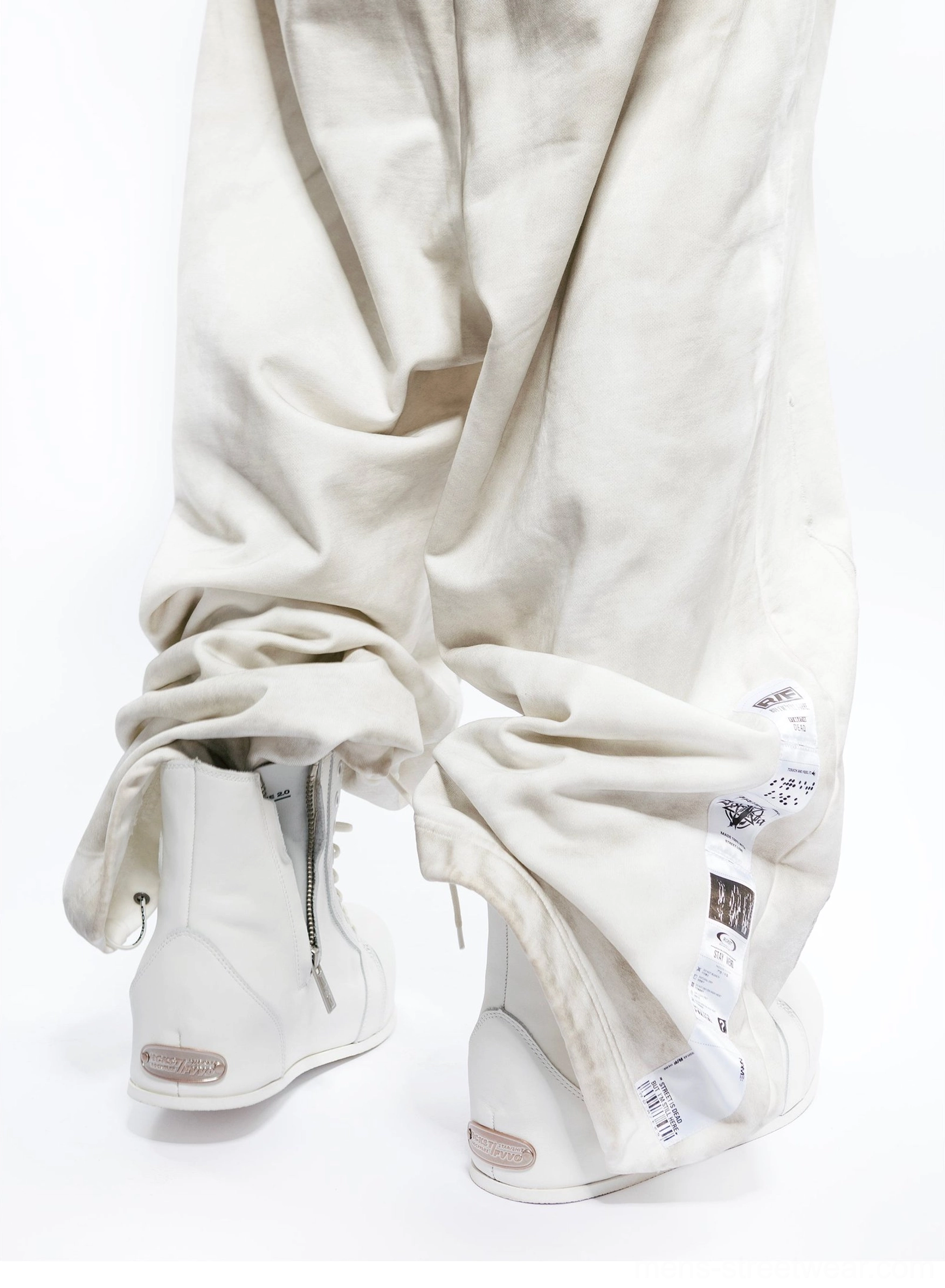 Rear three-quarter view of white leather high-top boots with side zipper, sculpted elevated sole, and architectural streetwear shape
