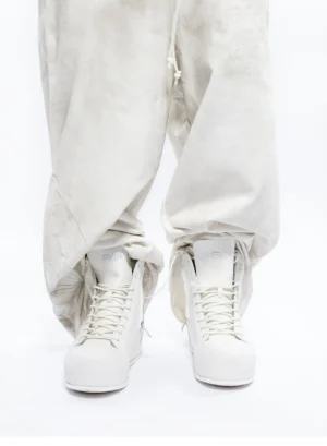 White leather high-top fashion boots worn with relaxed off-white trousers in a clean monochrome Korean streetwear outfit