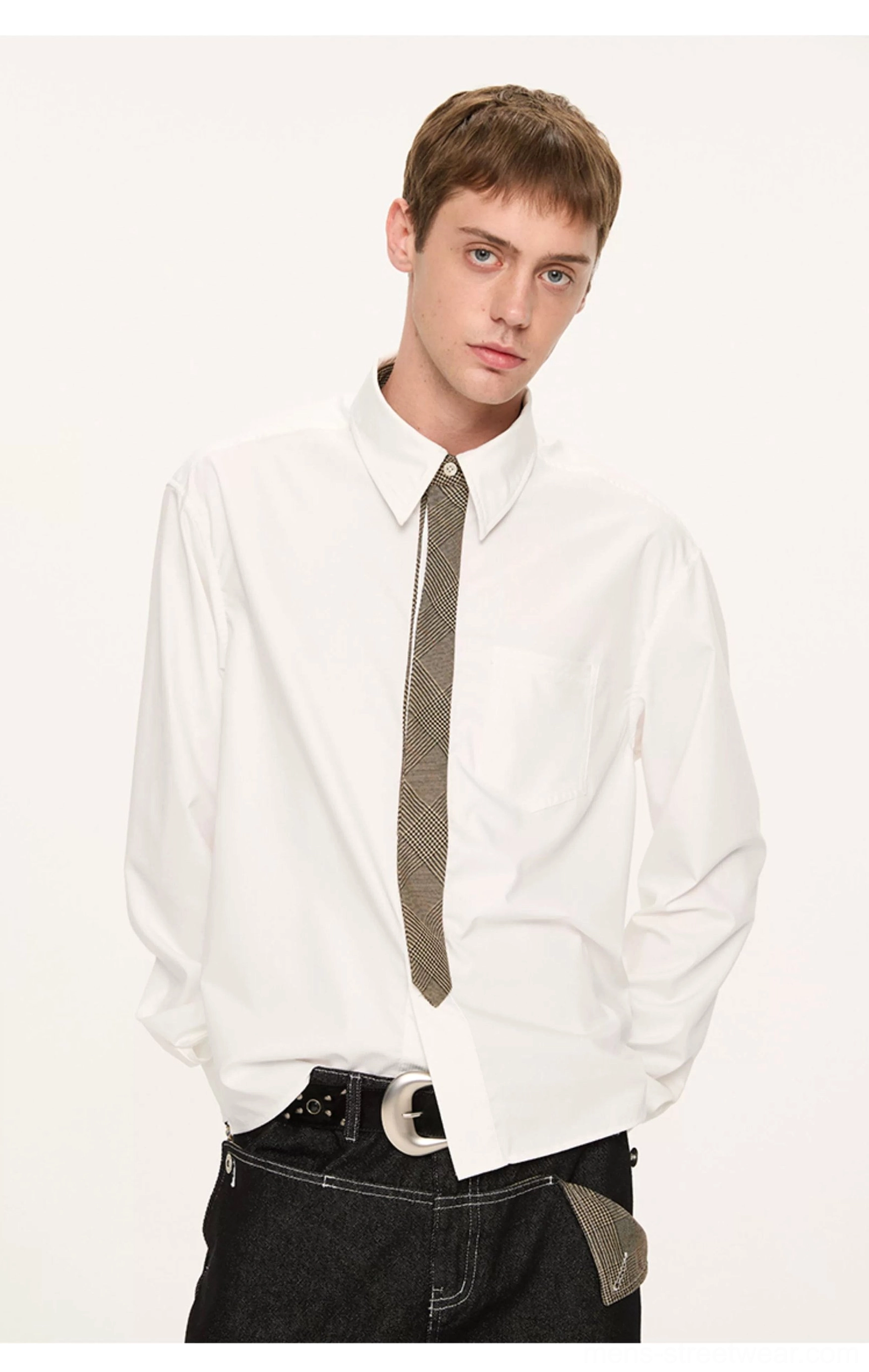 Front view of a white long-sleeve shirt with grey solid tie and chest pocket styled with black jeans