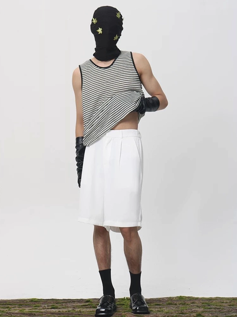 White longline Bermuda shorts with subtle front pleats and tailored waistband styled with a striped tank top in an avant-garde streetwear outfit