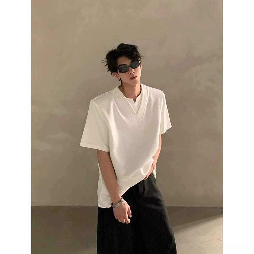 White loose fit deep V notched neck short sleeve shirt styled with sunglasses and wristwatch in a minimalist studio