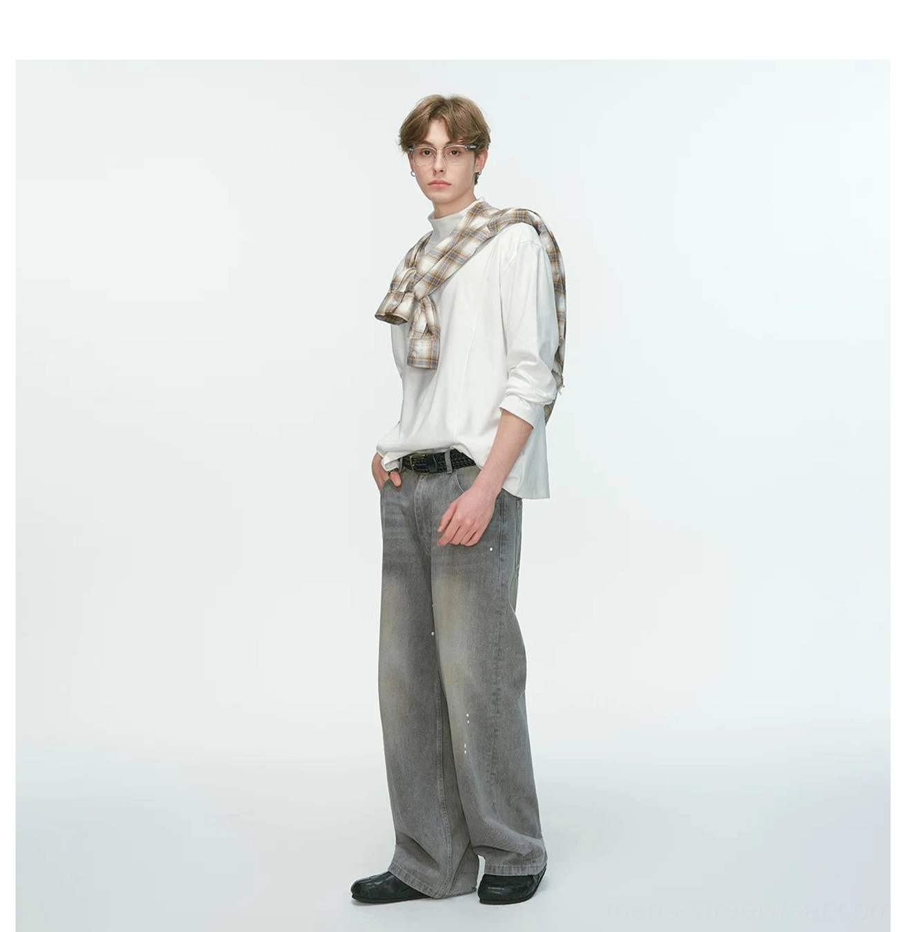 White men's mock neck streetwear top shown in a three-quarter view with plaid shoulder layering and relaxed gray wide-leg jeans