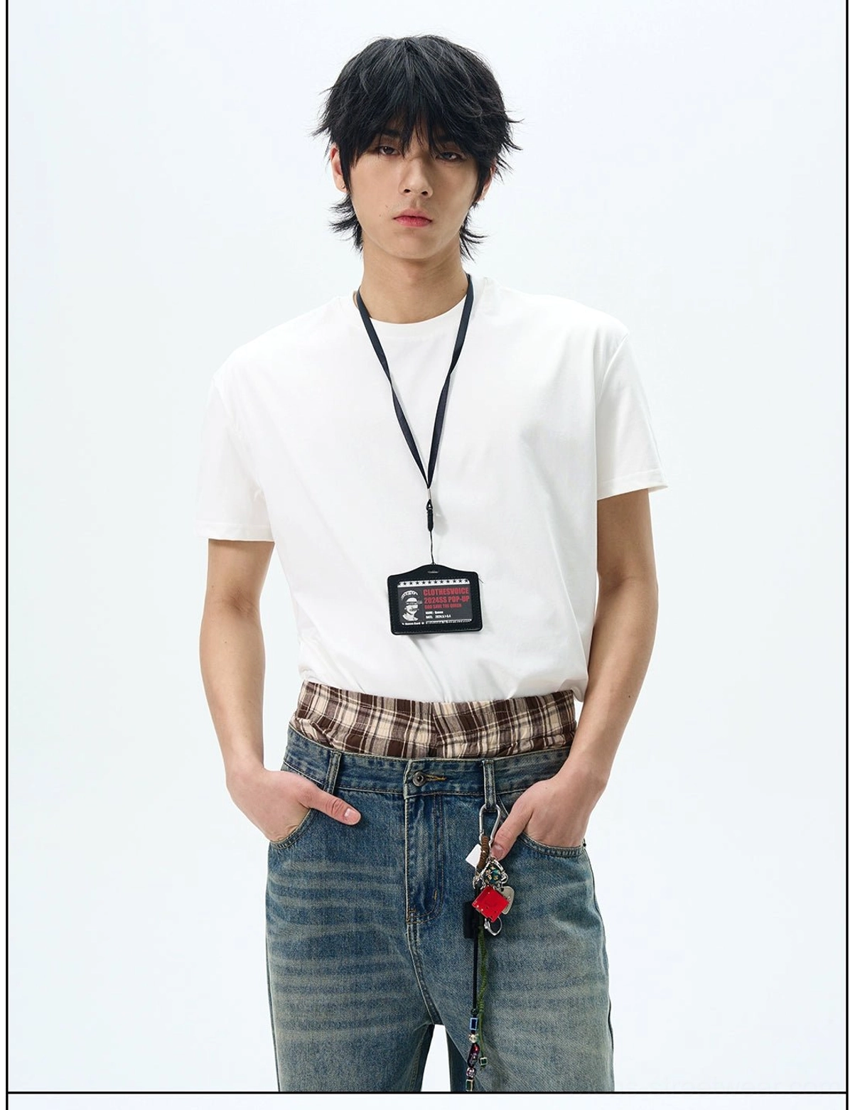 White minimalist crew neck t-shirt with exposed plaid inner layer, ID lanyard, and denim accessories