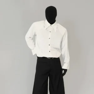 White minimalist Korean streetwear button-down shirt shown in three-quarter front view with pointed collar and relaxed silhouette