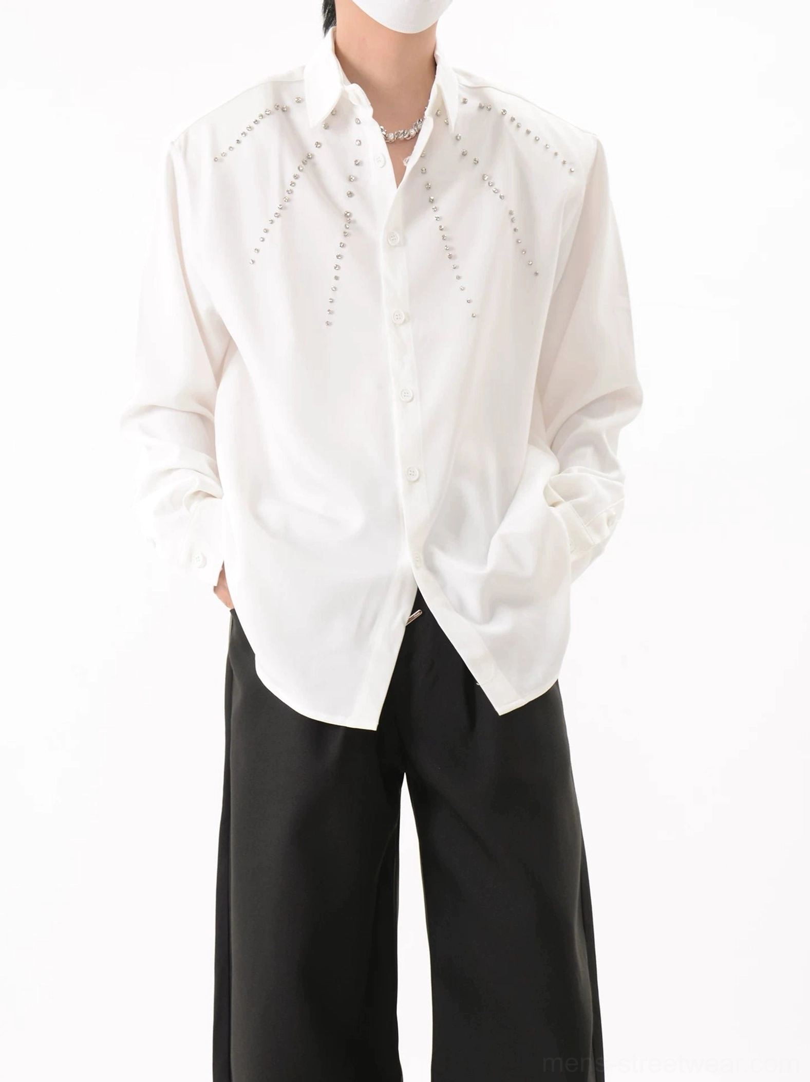 White Nova Burst studded overshirt in a three-quarter front view with pointed collar, button placket, relaxed fit, and black wide-leg pants