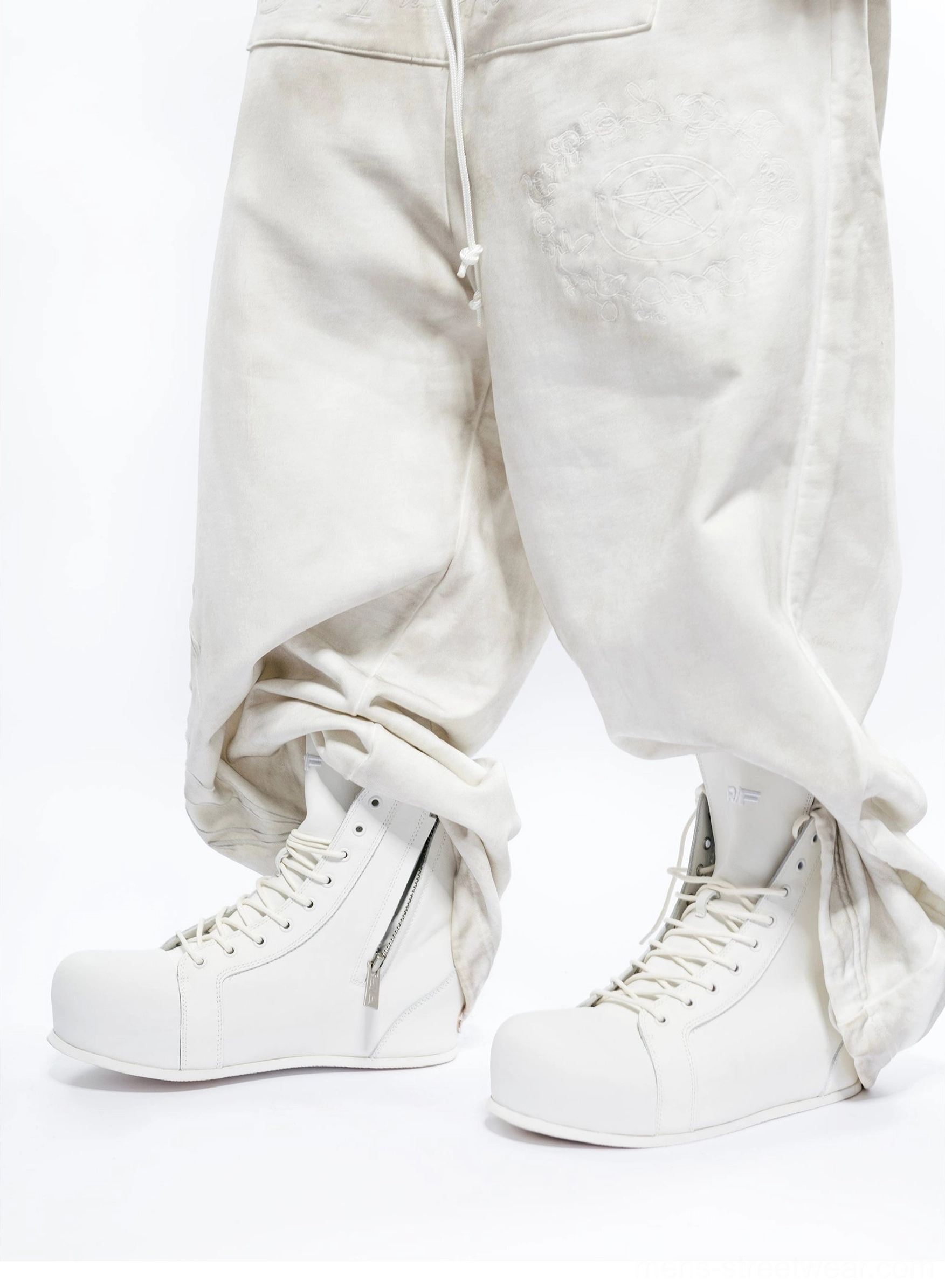 White open-heel leather high-top boots styled with loose cargo pants, visible side zipper, lace-up front, and rounded toe