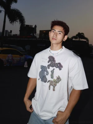 White oversized animal graphic T-shirt front three quarter view with plaid horse elephant duck rabbit and pony artwork in relaxed streetwear styling