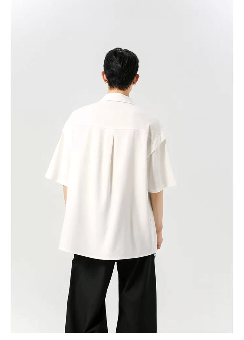 White oversized button shirt shown from the back with a clean solid-color finish and flowing relaxed silhouette