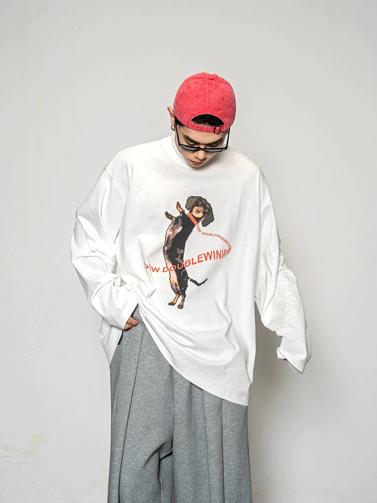 Three quarter front view of a white oversized dachshund print long sleeve streetwear T-shirt with playful retro graphic details