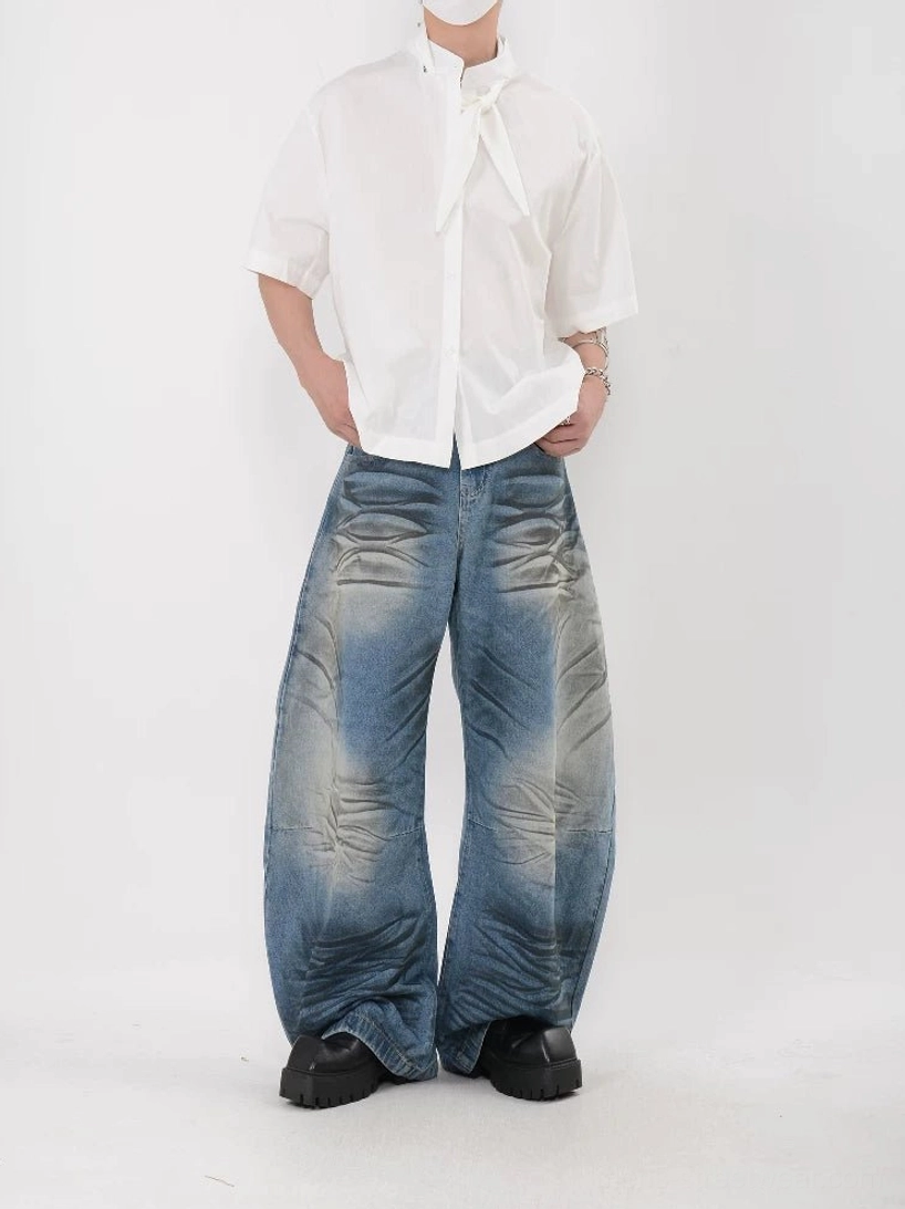 White oversized knot collar shirt with loose boxy fit, short sleeves, straight hem, washed jeans, and black platform sneakers