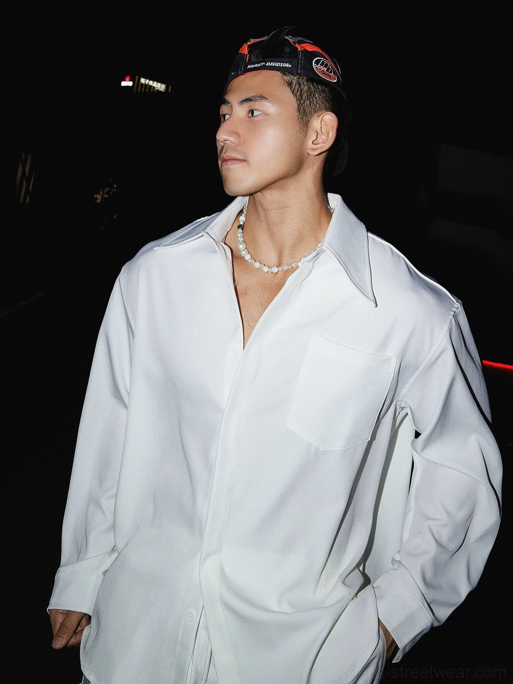 Close-up of white oversized men's streetwear dress shirt showing pointed collar chest pocket and relaxed front fit