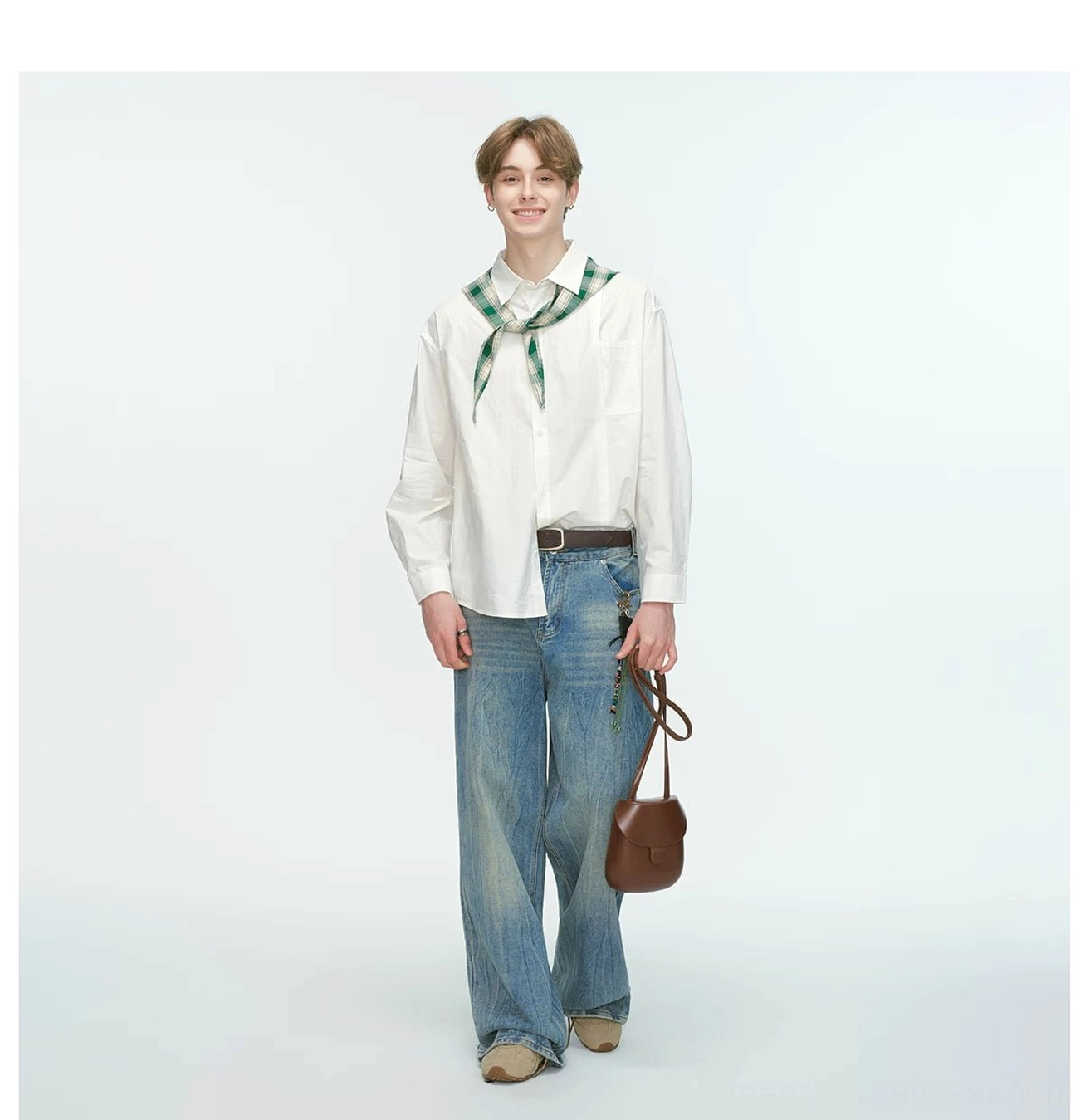 White oversized relaxed poplin shirt paired with wide-leg blue denim jeans green neckerchief and brown crossbody bag