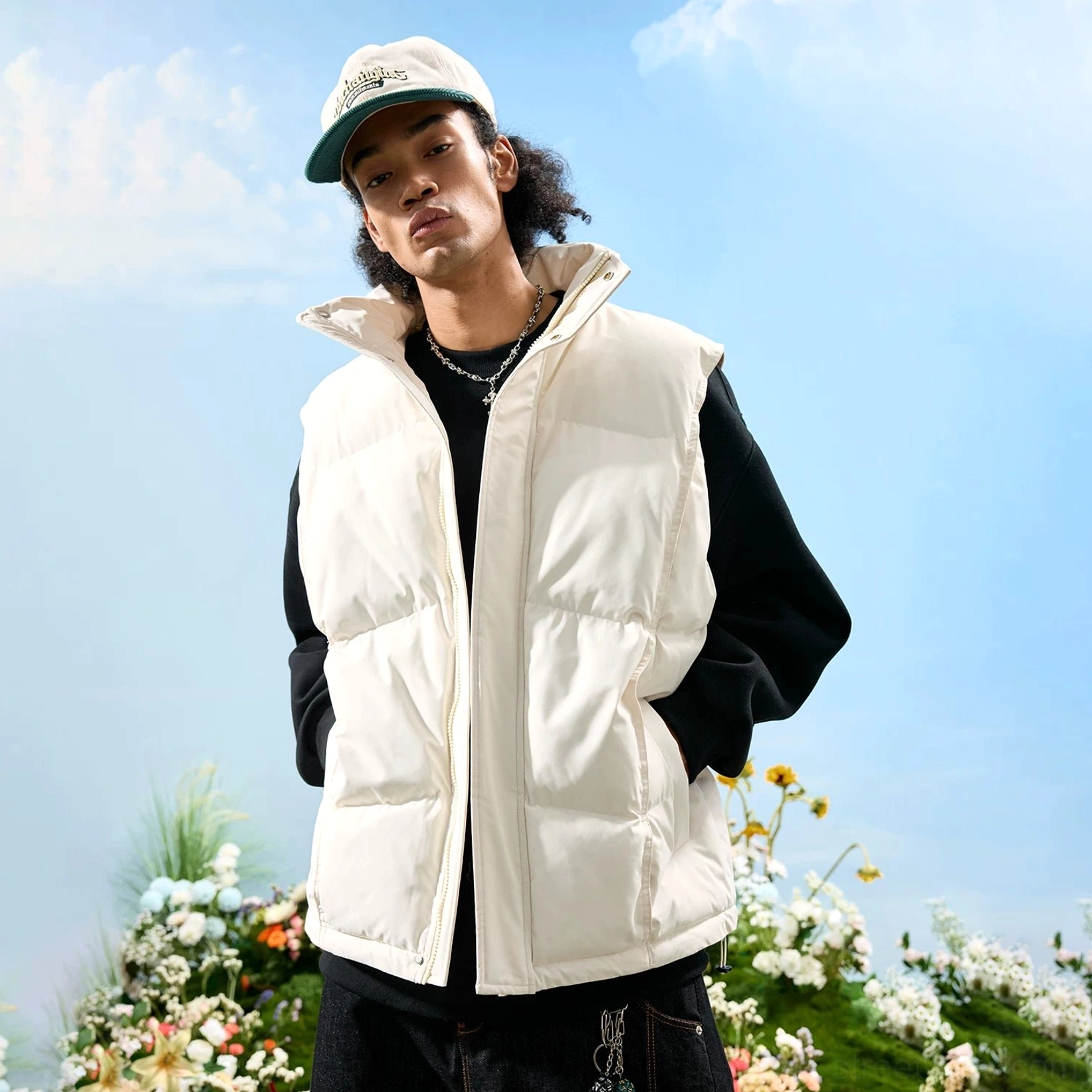 White oversized puffer vest styled with a black top and silver necklace in a relaxed monochrome streetwear outfit