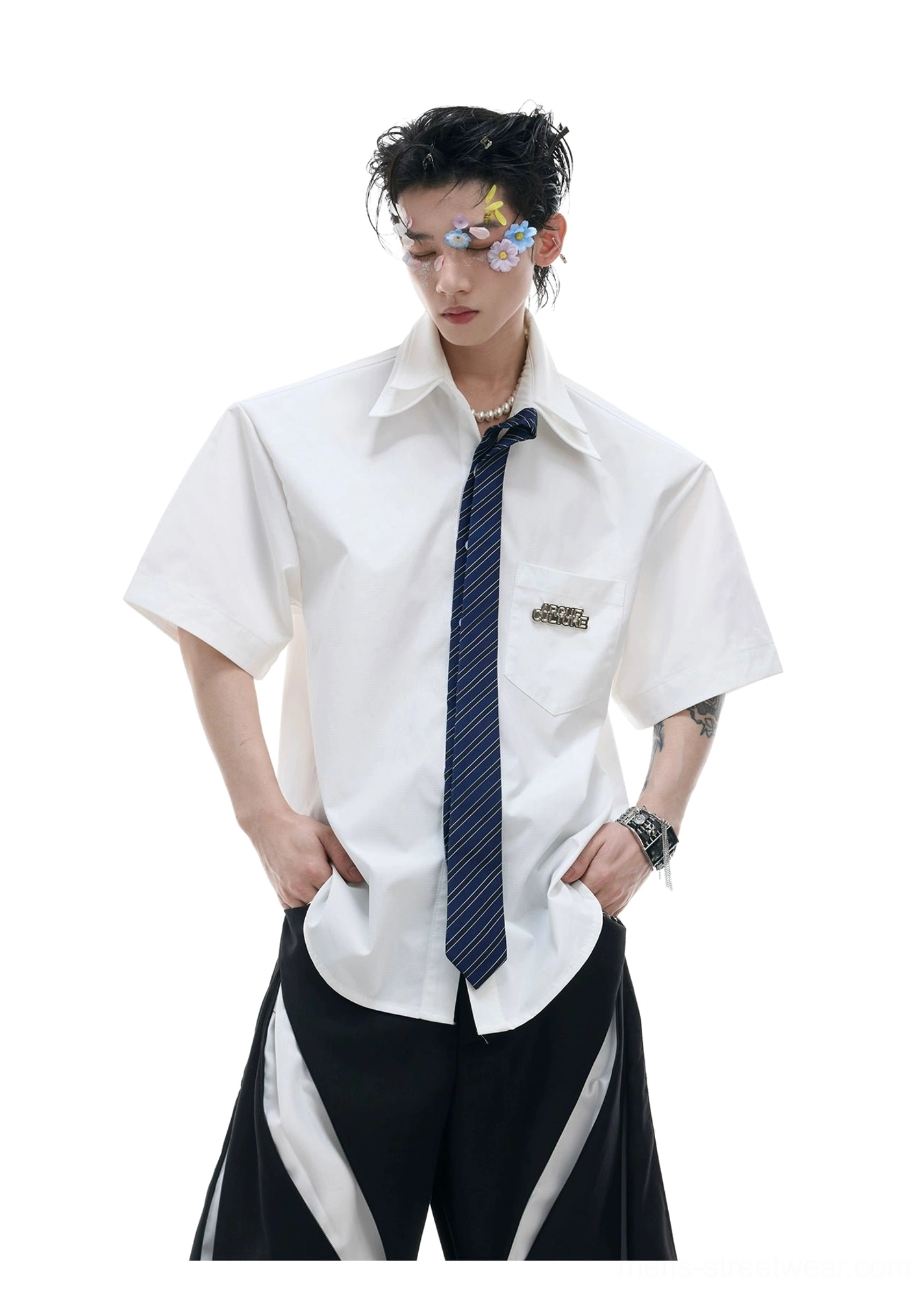White oversized short sleeve shirt with dark blue tie and curved hem styled with wide leg trousers