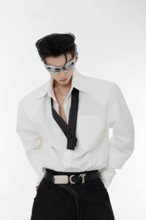 White oversized shoulder pad tie-neck streetwear shirt front close-up with black neck tie, chest pocket, and structured shoulders