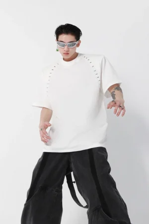 White oversized unisex streetwear T-shirt shown from the front with padded shoulders, industrial staple-style stitching, crew neck, and relaxed silhouette