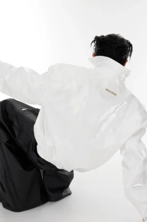 White padded shoulder vegan leather cropped jacket rear view showing smooth glossy streetwear finish and structured collar