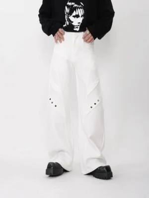 White high-waisted paneled wide-leg techwear trousers with geometric seams and metal thigh eyelets styled with a black cropped sweatshirt and chunky platform shoes