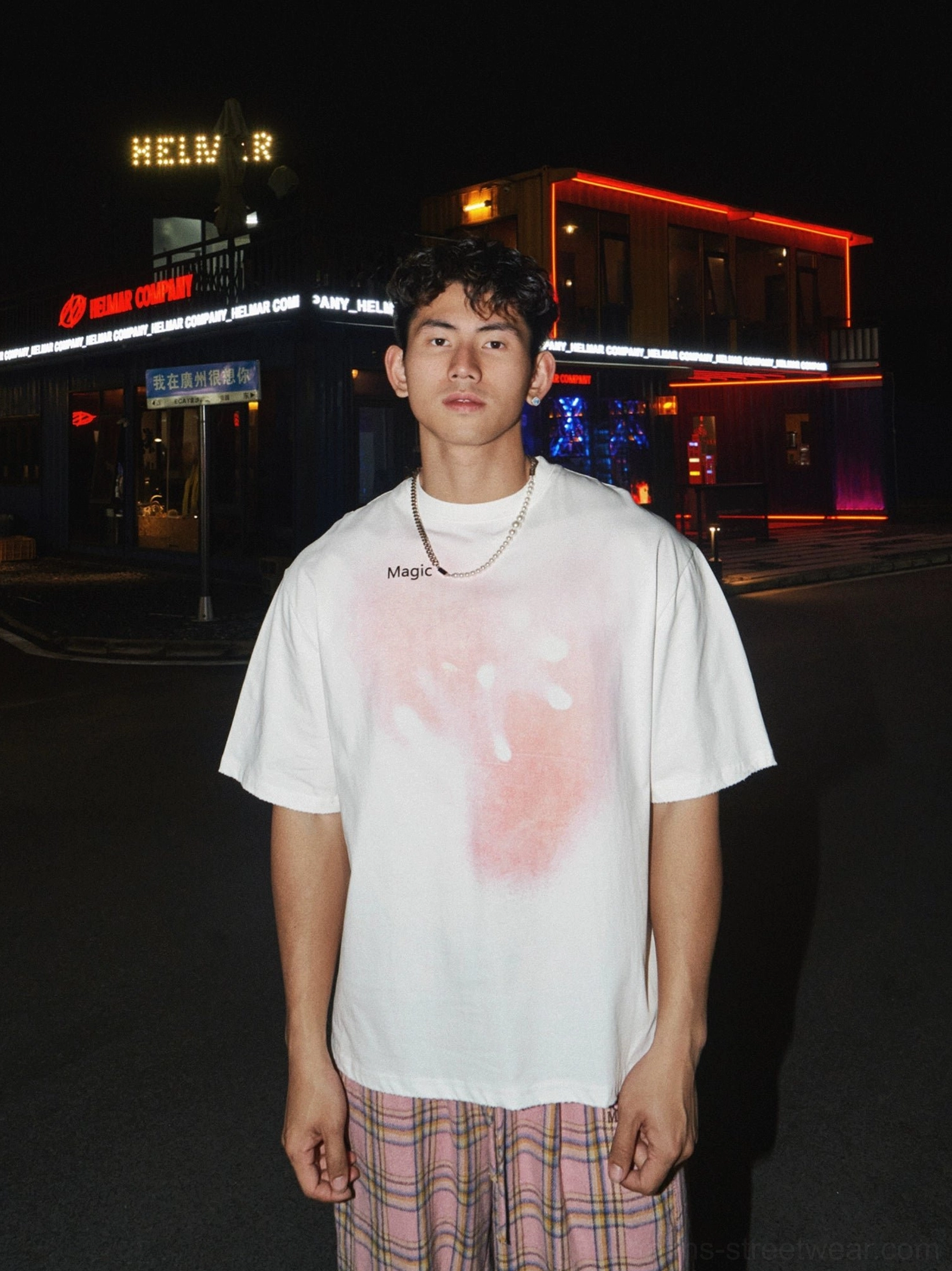 White oversized pink gradient graphic T-shirt with Magic chest logo paired with pink plaid trousers in a Korean streetwear look