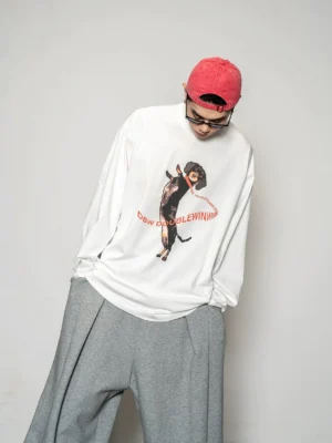 Close up view of white oversized long sleeve streetwear tee featuring a playful dancing dachshund graphic and red retro typography