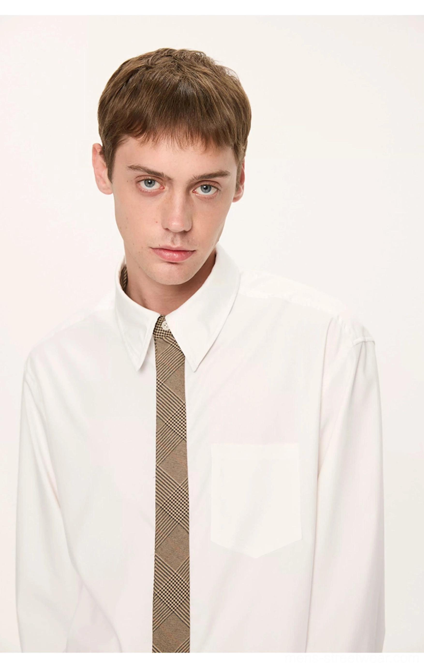 Close-up of a white pointed collar shirt with brown plaid tie and front chest pocket