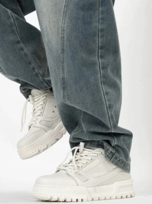 White Rampart chunky platform sneakers shown from a low front angle with smooth matte upper, round toe, lace-up closure and serrated rubber outsole