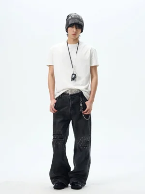 White relaxed crew neck t-shirt styled with a beanie, wide-leg studded jeans, pendant necklace, and jeans chain