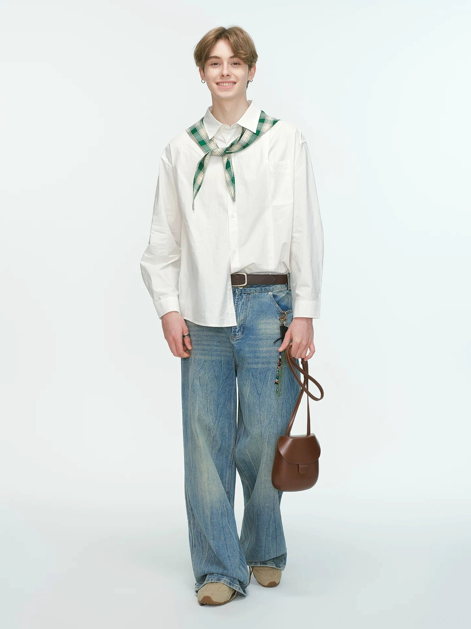 White relaxed poplin shirt styled with green plaid neckerchief blue jeans and brown leather accessories