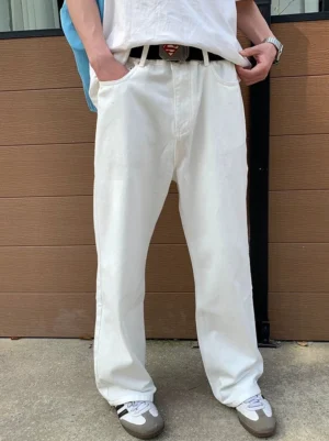 White relaxed straight-leg jeans styled with a white T-shirt and casual sneakers in an outdoor Seoul-inspired streetwear setting
