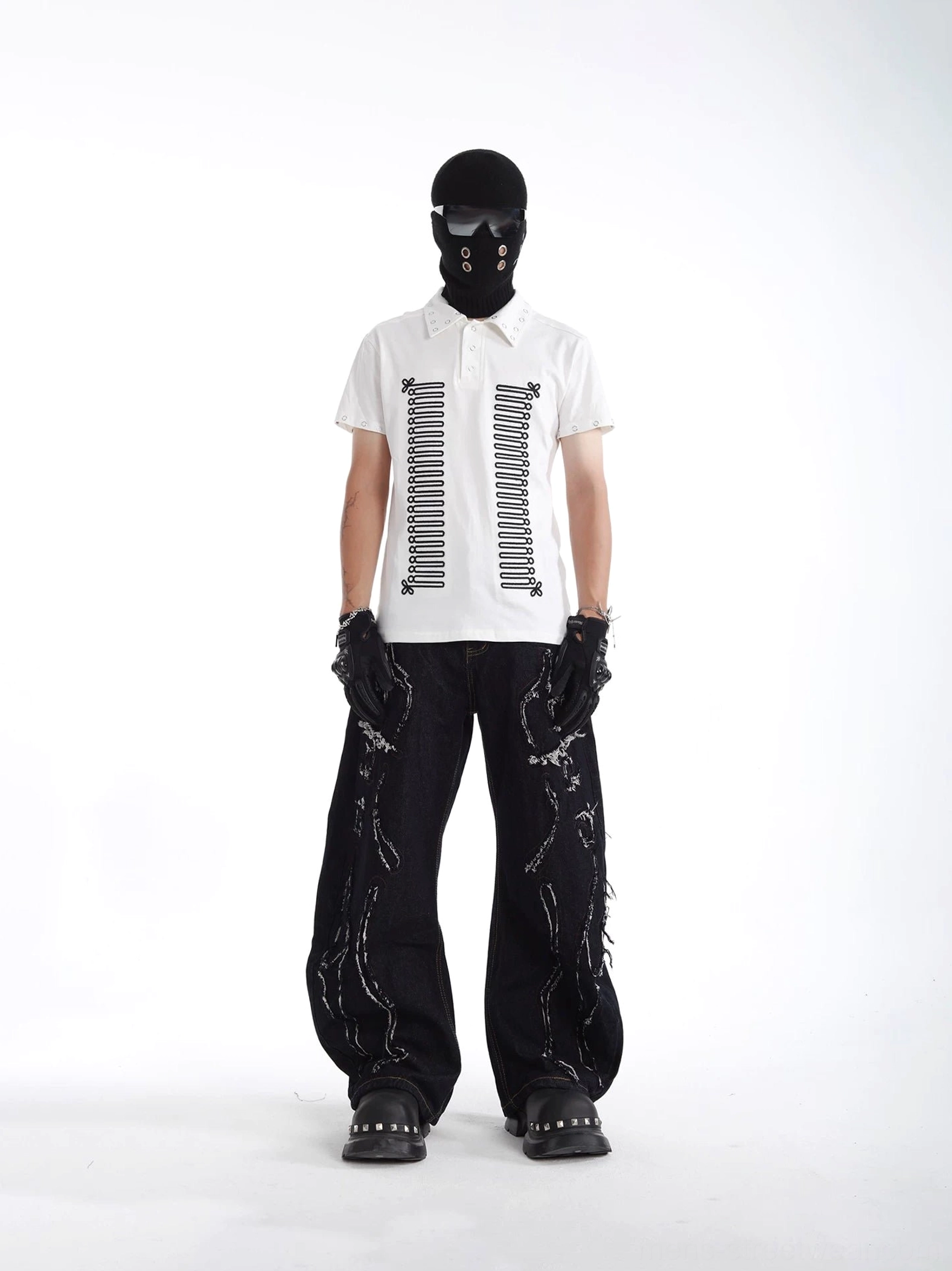 White skeleton print polo shirt featuring black front artwork, metal eyelet trim, and short sleeves styled with ripped black jeans