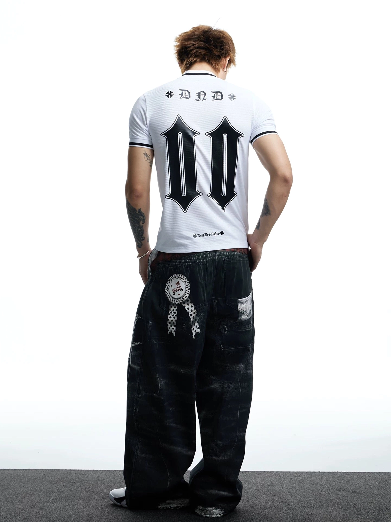 Full rear outfit view of a white soccer jersey mesh T-shirt with large black number 00 back print styled with wide-leg streetwear jeans