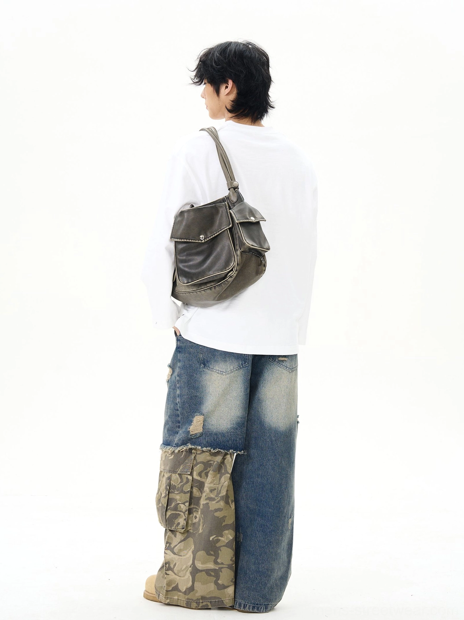 Back-side view of a white relaxed-fit split-neck cotton shirt worn with camo denim patchwork wide-leg jeans and crossbody bag