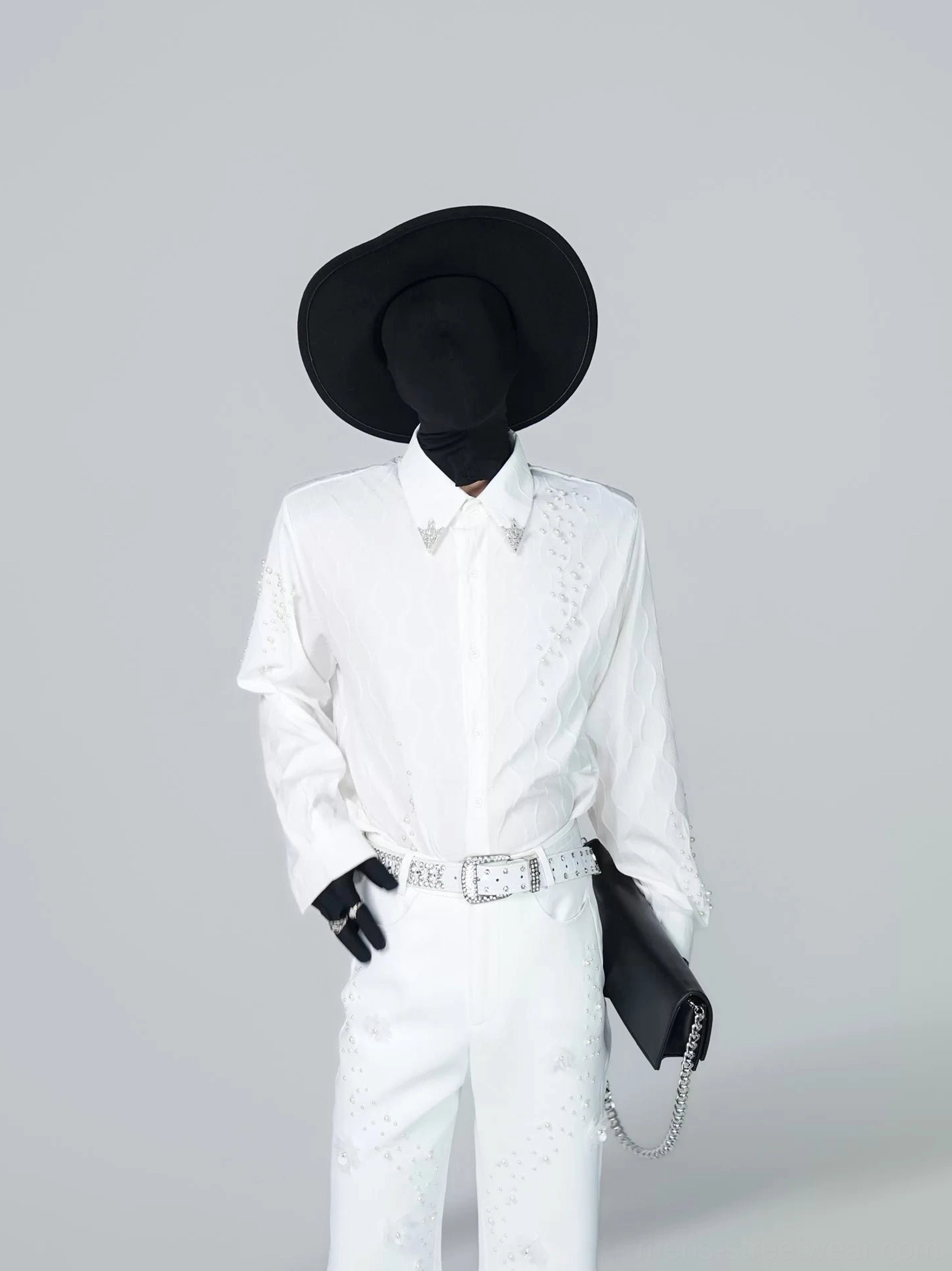 Front full-body view of a white starfall embellished shirt styled with matching wide-leg trousers, black wide-brim hat, rhinestone belt, and chain clutch