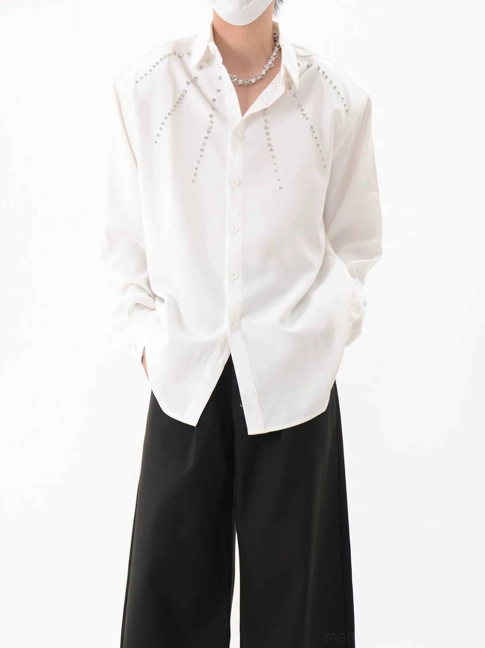 White studded oversized streetwear overshirt shown from the front with silver-tone radial shoulder and chest embellishment