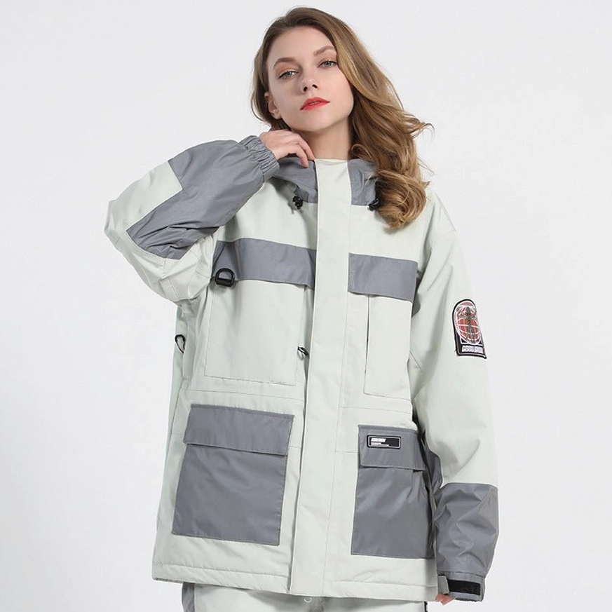White unisex reflective color block ski jacket front three-quarter view showing gray hood trim, cargo pockets and sleeve patches