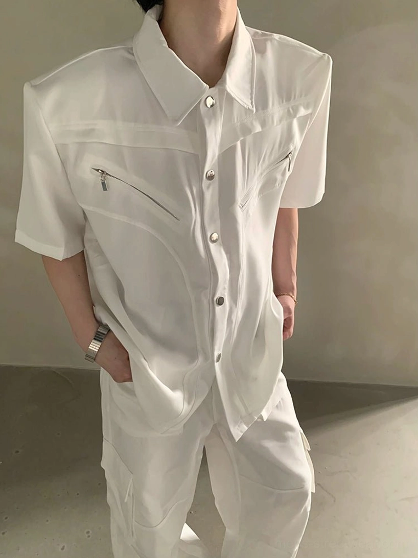 Flat lay white short sleeve utility shirt showing structured pointed collar, wide sleeves, chest zipper detail, button front, and draped silhouette